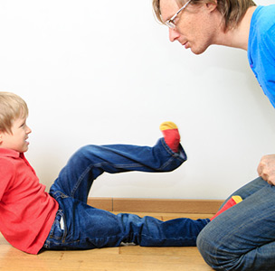 Young boy kicking adult